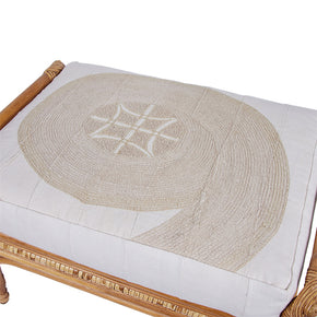 (CUSHION DETAIL VIEW) Rattan Ottoman with African Embroidery Upholstery. Vintage ottoman with double-sided cushion in embroidered white cotton.
