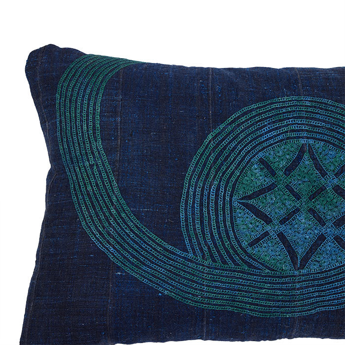 (SIDE DETAIL) African Embroidery Pillow Indigo/Green II. Made from a vintage Hausa Chief’s Robe, known as a Boubou. Hausa is the largest tribal group in Nigeria. Floss hand embroidery over striped cotton fabric woven in narrow panels. Backed with natural linen. Invisible zipper closure, feather and down fill. 15" x 27"