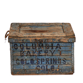 (FRONT VIEW) Vintage Bread Delivery Crate - Well preserved, clean, worn, and used old wooden box with original blue paint visible rust and ageing stamped with block letters in dark blue "Columbia Bakery Colo. Springs Col." Rope handles. Lid opens on hinges to clean wood inside. 17" H x 27" W x 20" D